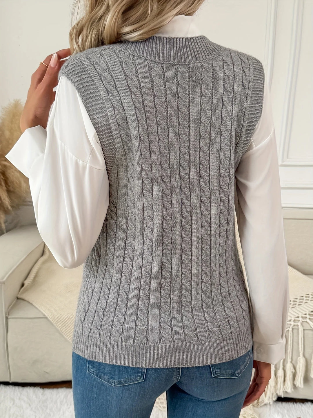 Grå sweatervest i kabelstrik set bagfra